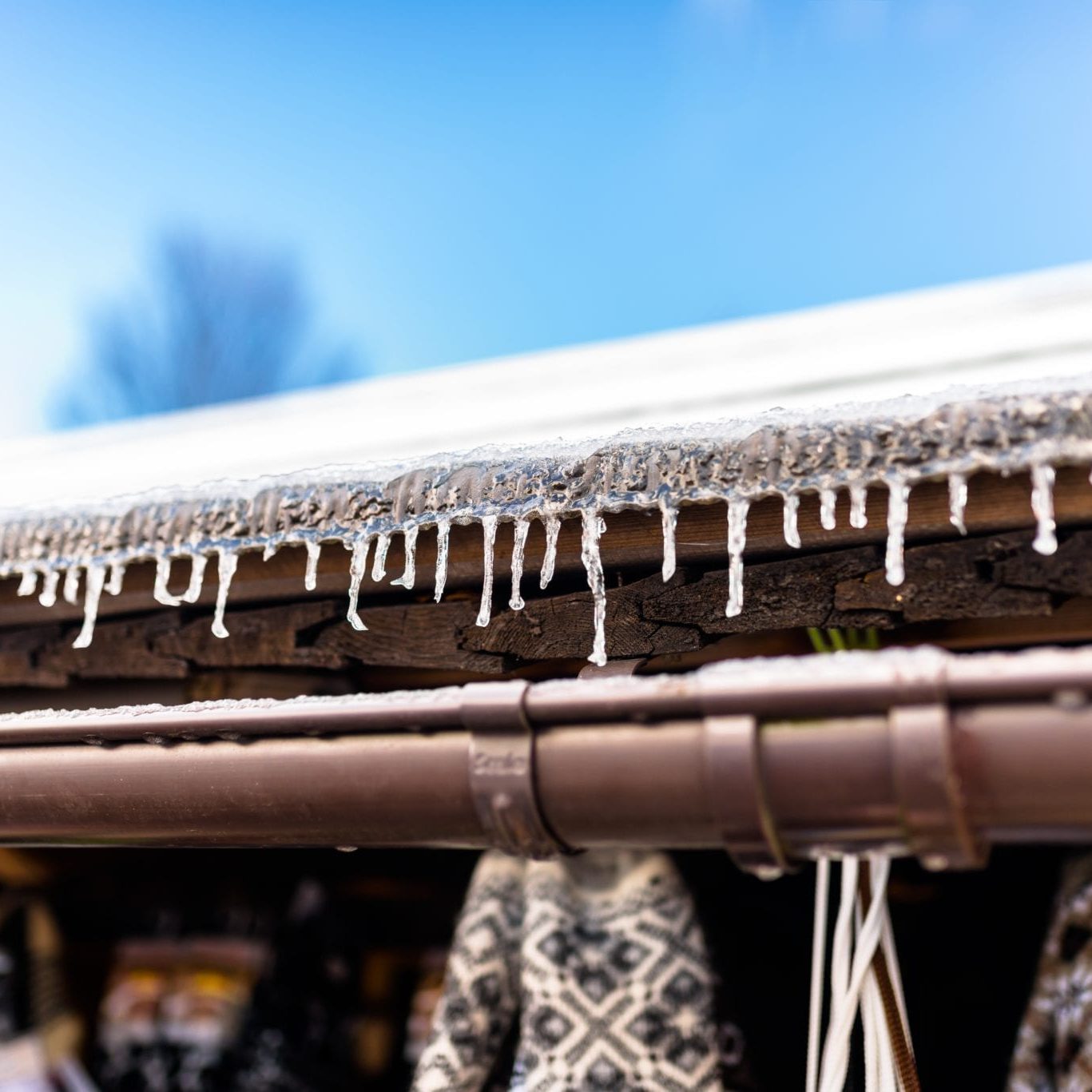 hanging-icicles-from-the-roof-of-a-wooden-building-GQPCP9X